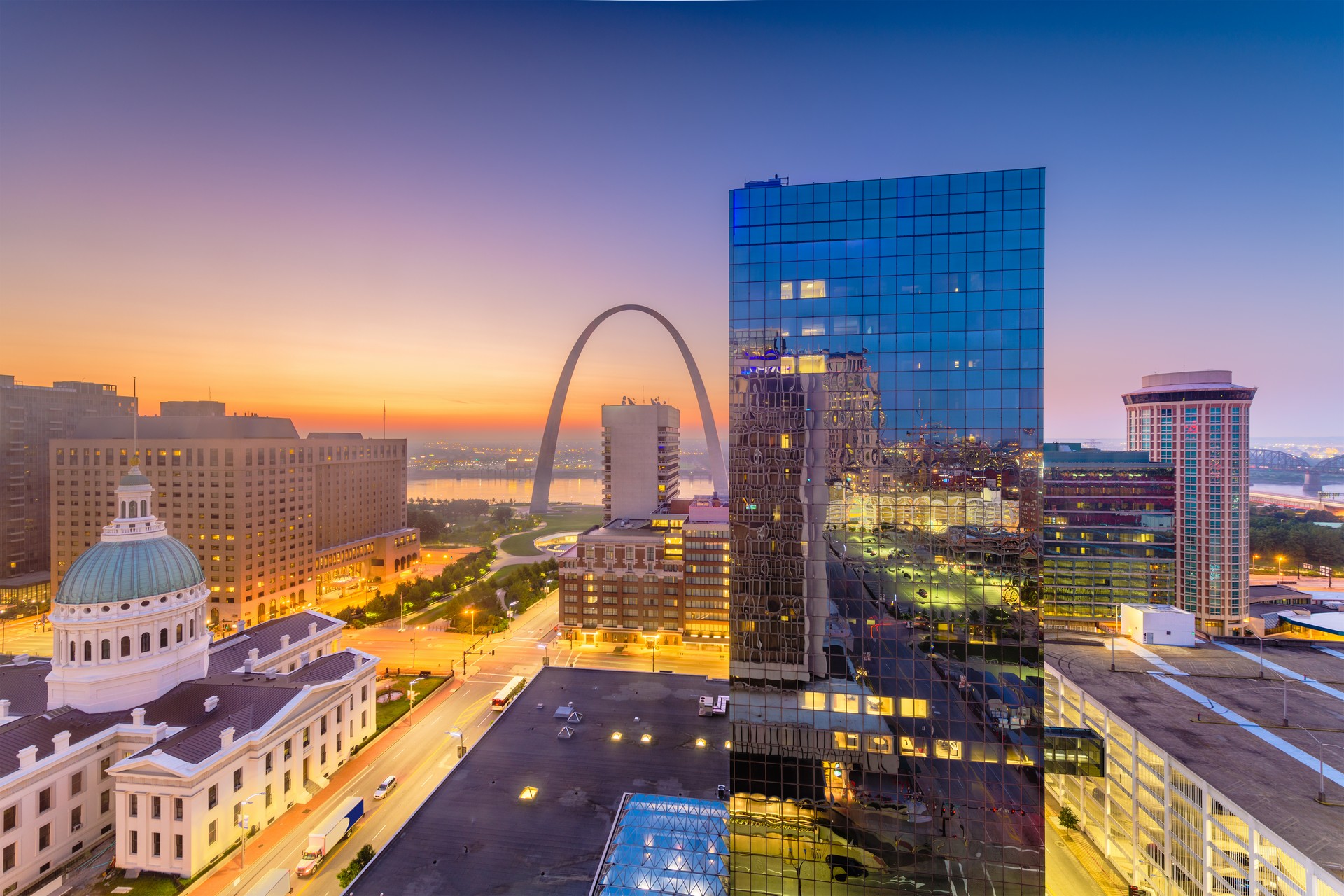 STL downtown cityscape with the arch and courthouse at dusk.
